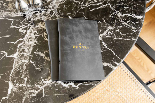 Branded leather menu binder on restaurant table setup