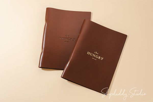 brown leather menu holder with ring mechanism for bar menu