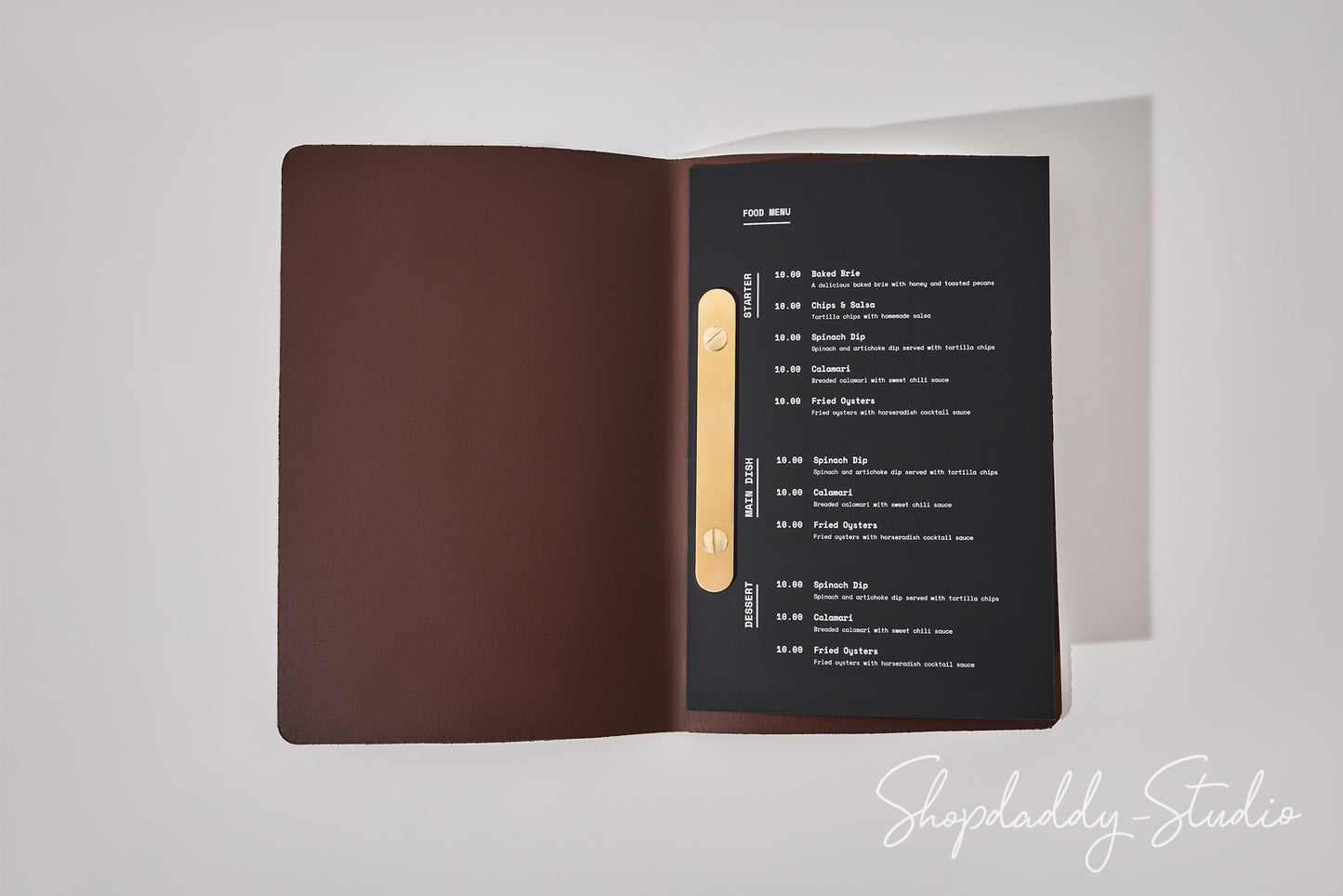 An open menu booklet or folder on a light gray background. The left page is a solid dark brown cover, and the right page is black with white text listing items and a vertical gold accent strip.