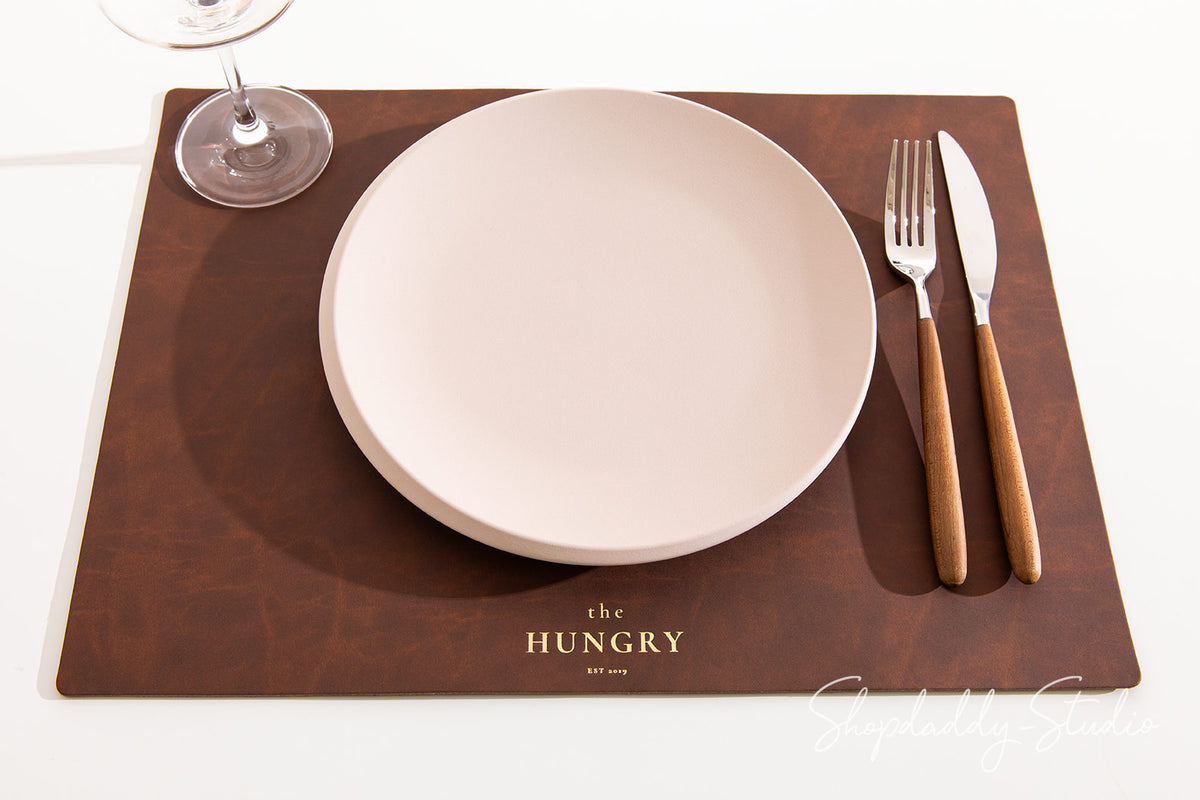 Durable antique brown leather placemat made from sustainable recycled materials.