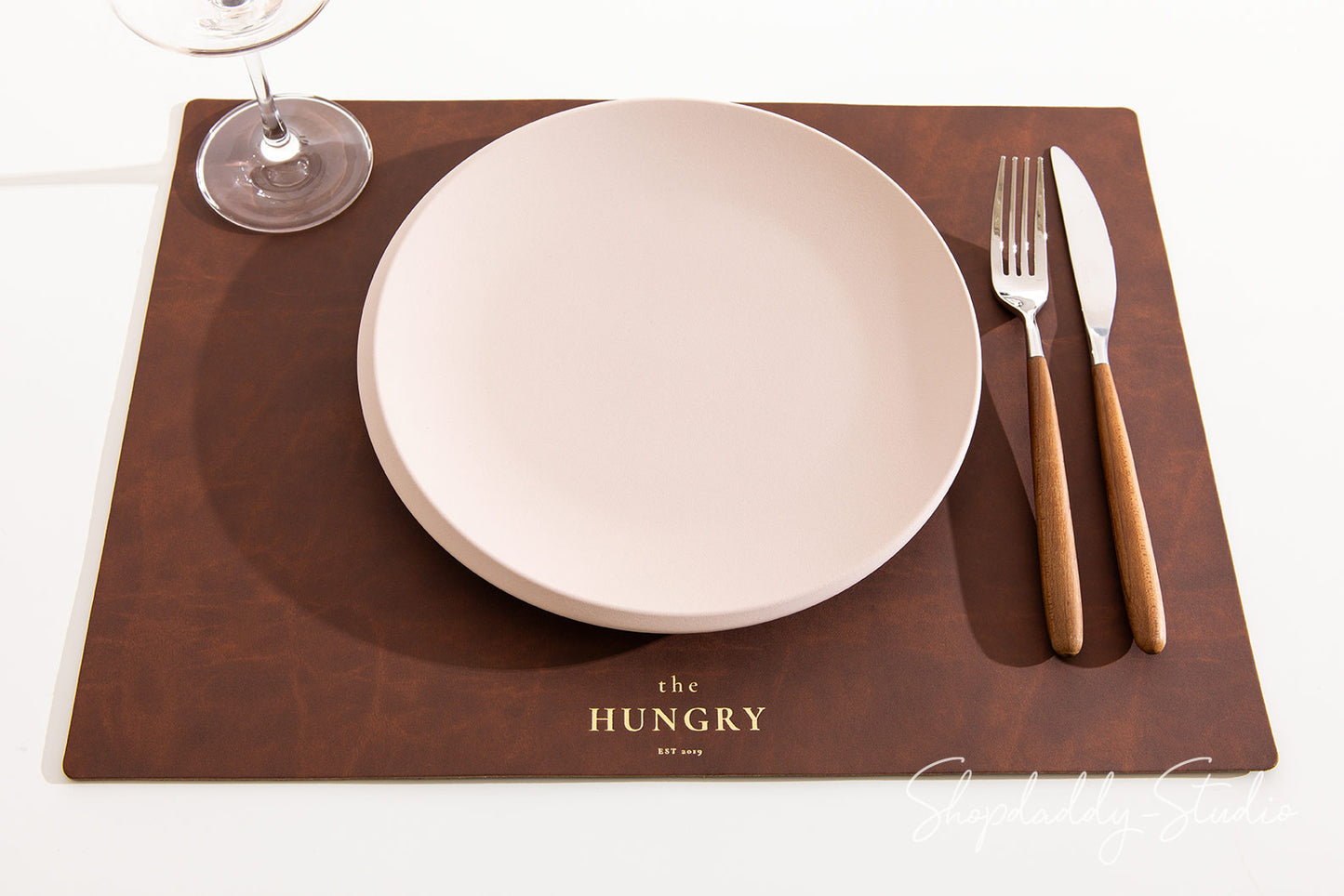 Durable antique brown leather placemat made from sustainable recycled materials.