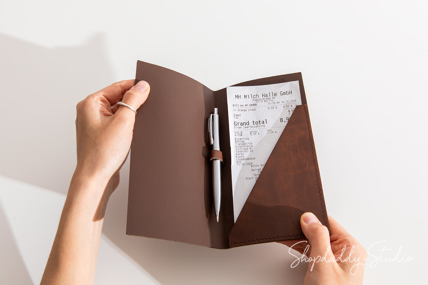 Elegant check holder in antique brown recycled leather, designed with a pen loop.