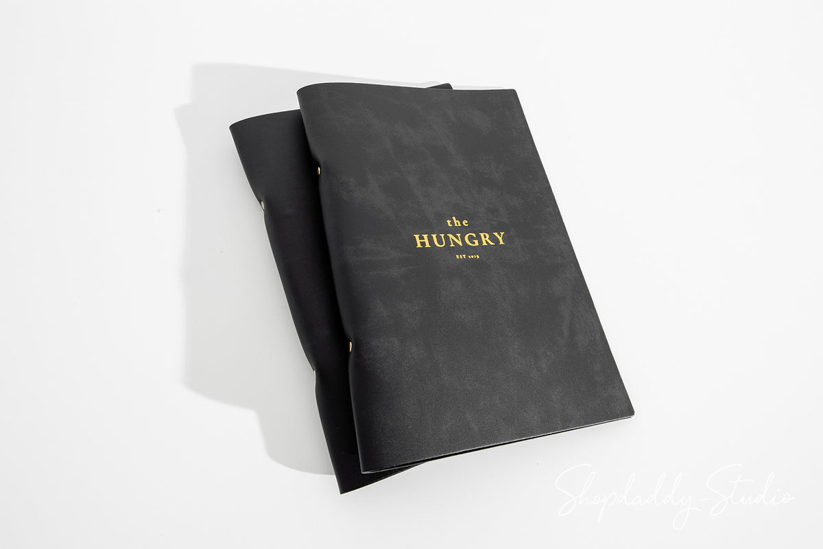 Modern menu cover shown in upscale hospitality interior