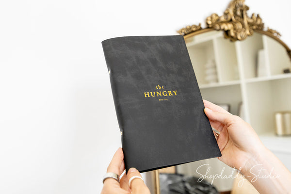 Black leather menu binder with minimalist logo engraving