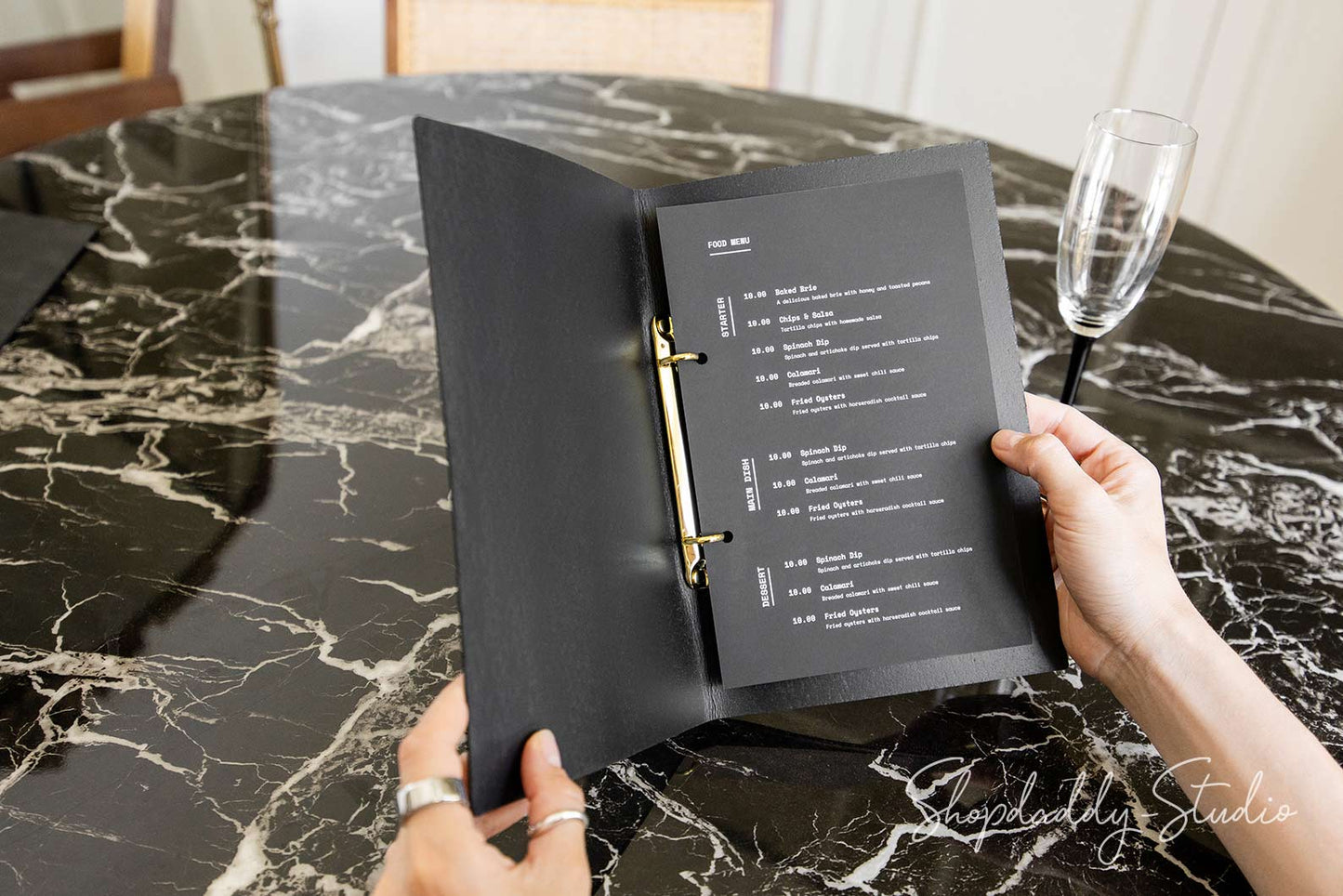 Open leather menu folder showing inserted menu pages in binder rings
