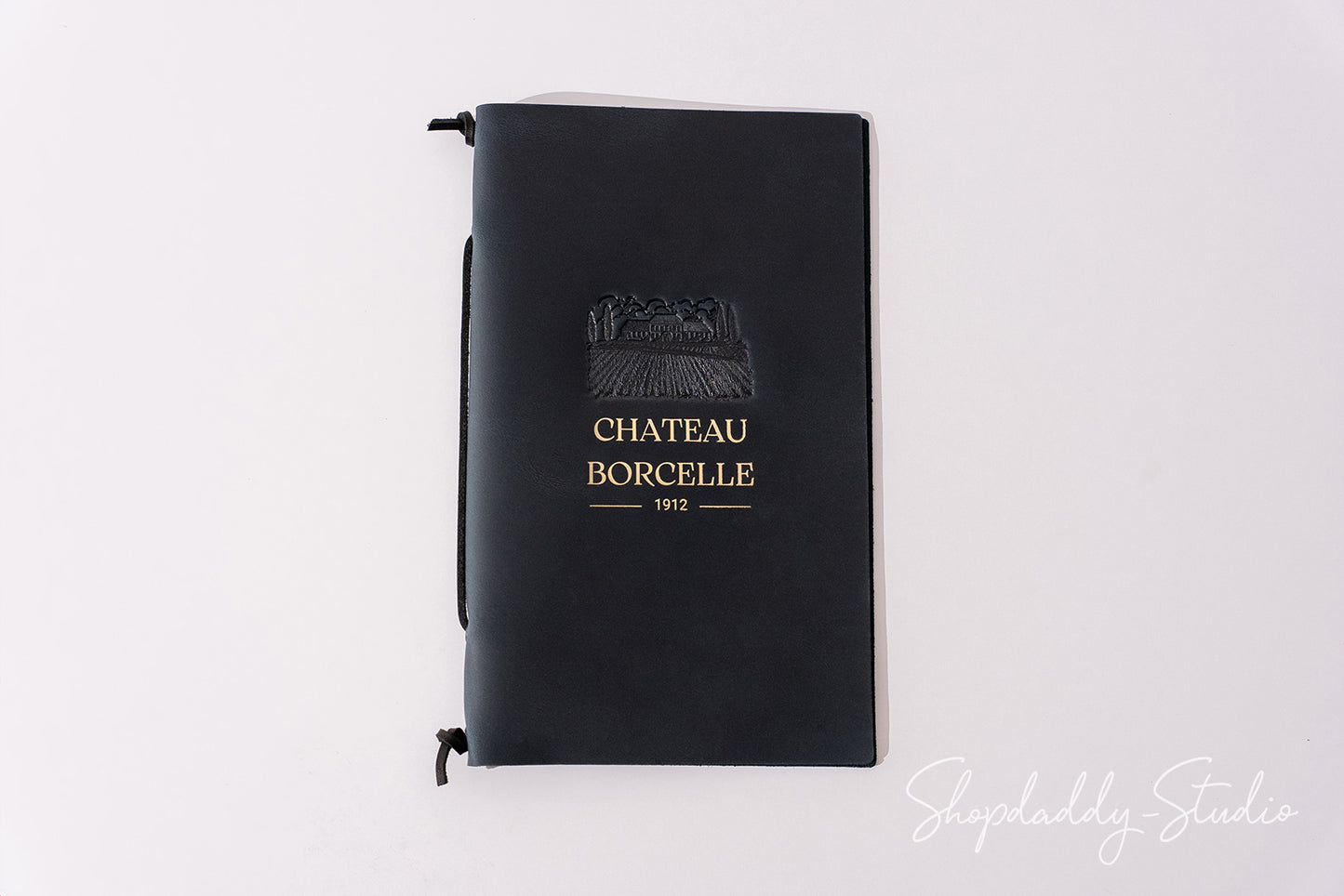A black hardcover notebook with a gold embossed logo and text reading 'CHATEAU BORCELLE 1972' on the front cover, photographed against a plain white background.