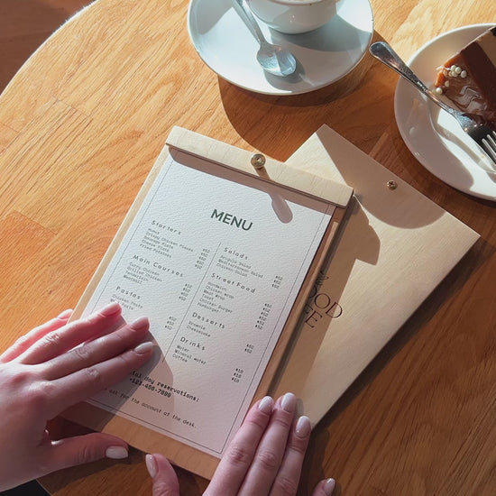 Close-up of a wooden menu board, highlighting the smooth plywood surface and central brass screw detail