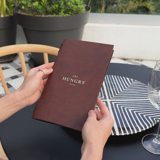 Recycled antique brown leather menu cover with elastic band, perfect for restaurants.