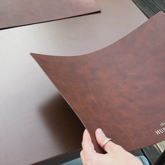 Recycled antique brown leather dining placemat with a rustic finish.
