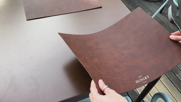 Recycled antique brown leather dining placemat with a rustic finish.